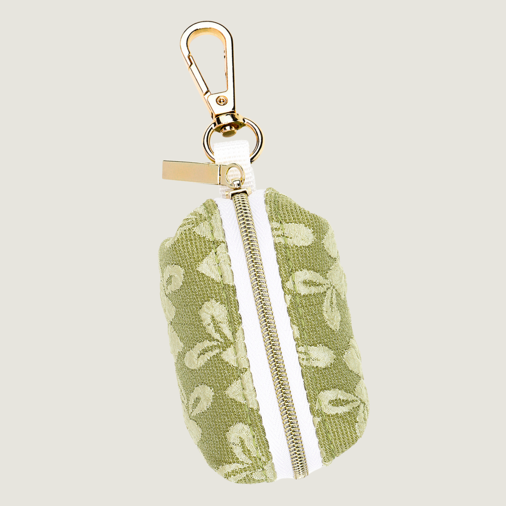 Jaap & Co Botanical Glow collectie: een lichtgroene poepzakjeshouder met lichtere geborduurde bloemenprint met gouden hardware