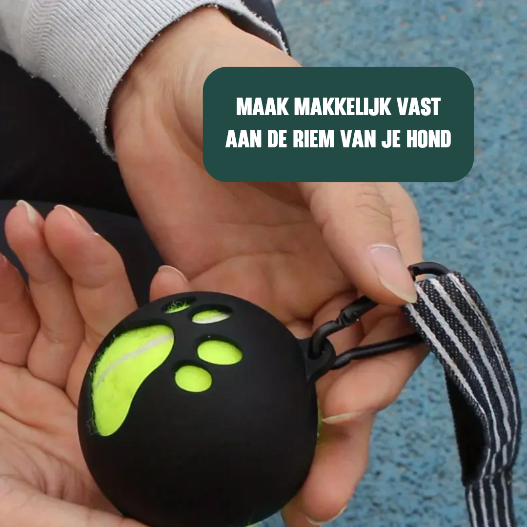 Zwarte tennisbalhouder met tennisbal erin die vastgehouden wordt door een persoon en met de clip vast zit aan een riem.