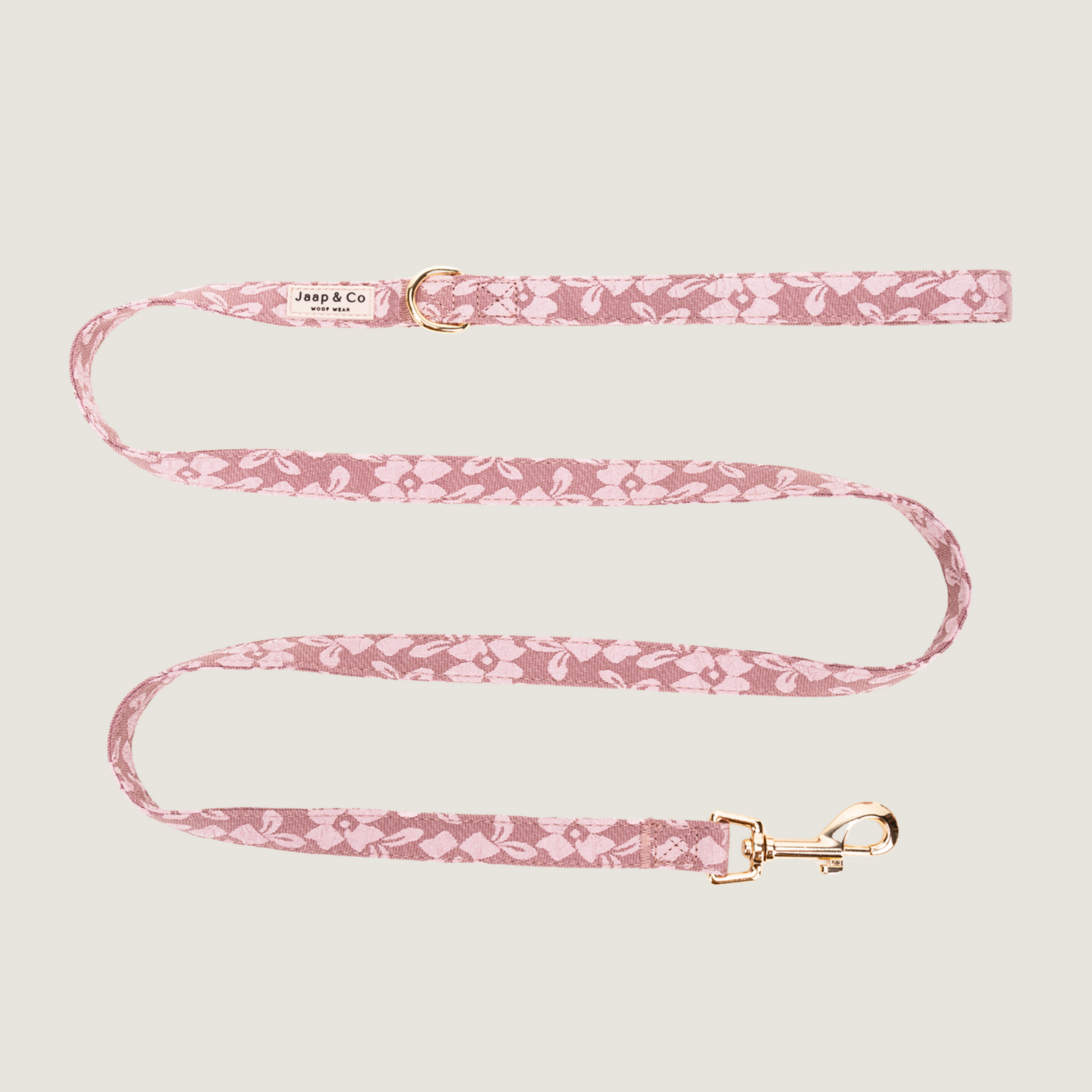 Oud roze hondenriem met lichtroze bloemenprint en gouden details, bevat een D-ring om poepzakjeshouder aan vast te klippen. Er zijn bijpassende producten van de Rosé Dusk van Jaap &amp; Co