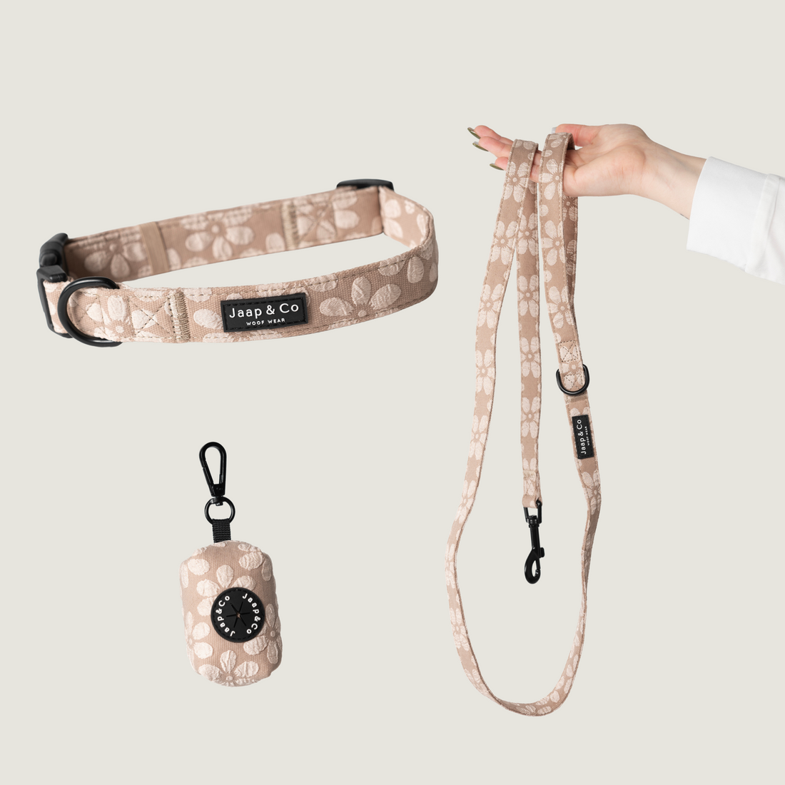 Set met de hondenhalsband, riem en poepzakjeshouder van de Jaap &amp; Co Blush Elegance collectie. Een warme beige kleur met lichte bloemenprint.